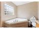 This bathroom features a jacuzzi tub, a tiled privacy window, and a toilet at 104 N Green St, Selma, NC 27576