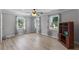 This bedroom features wood floors, three windows with curtains, and a ceiling fan at 104 N Green St, Selma, NC 27576