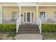 Charming front porch features decorative front door, brick stairs, and well-manicured hedges at 104 N Green St, Selma, NC 27576