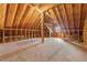 Spacious unfinished attic space with exposed wood beams, plywood flooring, and a window providing natural light at 108 Boone St, Chapel Hill, NC 27516