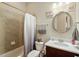 Bathroom featuring a tub with shower, and tile surround, dark vanity cabinet and neutral colored paint at 108 Boone St, Chapel Hill, NC 27516