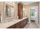 Bathroom showcasing double sinks, granite countertops, dark wood cabinets, and acces to bedroom at 108 Boone St, Chapel Hill, NC 27516