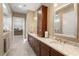 Bathroom featuring double sinks, granite countertops, dark cabinets, walk in closet access, and neutral paint at 108 Boone St, Chapel Hill, NC 27516