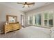 Bright bedroom with hard wood floors, ceiling fan, shuttered windows, and a dresser with a mirror at 108 Boone St, Chapel Hill, NC 27516