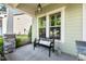 Inviting front porch with a black bench, decor, and green siding, offering a welcoming curb appeal at 108 Boone St, Chapel Hill, NC 27516