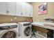 Laundry room boasting a front loading washer and dryer, white cabinets and a small sink at 108 Boone St, Chapel Hill, NC 27516