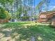 Expansive backyard boasts mature trees, green lawn, a shed, a deck, and space for outdoor activities at 1103 Brucemont Dr, Garner, NC 27529