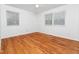 Sunlit bedroom with wood floors and two windows offering ample natural light at 1103 Brucemont Dr, Garner, NC 27529