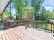 Inviting wooden deck with a decorative railing overlooks the private backyard with mature landscaping at 1103 Brucemont Dr, Garner, NC 27529