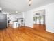 Open-concept living room with hardwood floors flowing into the kitchen area with modern white cabinetry at 1103 Brucemont Dr, Garner, NC 27529