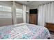 Cozy bedroom features bright windows, TV, wood dresser, soft lighting, and a comfortable floral patterned bed at 114 Short E St, Hillsborough, NC 27278