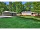 View of a well-maintained front yard with a carport adjacent to the brick house, creating ample parking and curb appeal at 114 Short E St, Hillsborough, NC 27278