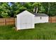 White outbuilding in backyard with double doors, surrounded by green grass and a wooden fence at 114 Short E St, Hillsborough, NC 27278