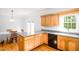 Kitchen with wood cabinets, gray countertops, and black appliances, next to an eat-in dining space at 1149 Highway Nc 87, Pittsboro, NC 27312