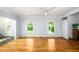 Bright living room featuring hardwood floors, two windows, ceiling fan and adjacent room access at 1149 Highway Nc 87, Pittsboro, NC 27312