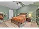 Cozy bedroom with a bed with orange bedding, nightstands, and a rustic wooden bed frame, carpet, and green walls at 115 Parkers Gate Dr, Youngsville, NC 27596