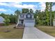 Charming two-story home with gray siding, brick stairs, a two-car garage, green lawn, and tree-lined background at 115 Parkers Gate Dr, Youngsville, NC 27596
