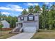 Beautiful two-story home with gray siding, white trim, lush lawn and brick stairs leading up to the front door at 115 Parkers Gate Dr, Youngsville, NC 27596