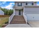 Close up of home's brick stairs leading up to front porch, two-car garage, gray siding and green front lawn at 115 Parkers Gate Dr, Youngsville, NC 27596