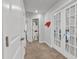 Bright hallway with neutral carpet, white walls, and white trim on doors and a view into decorated bedroom at 115 Parkers Gate Dr, Youngsville, NC 27596
