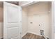 Bright laundry room with shelving, wood-look flooring, and white door at 115 Parkers Gate Dr, Youngsville, NC 27596