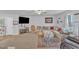 Spacious living room features plush sectional, neutral carpeting, ceiling fan, TV, and play area in the background at 115 Parkers Gate Dr, Youngsville, NC 27596