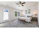Bright bedroom with a ceiling fan, carpeted floor, bench, and a scenic window view at 1211 Brown Velvet Ln, Apex, NC 27523