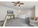 Neutral bonus room featuring plush gray carpeting, a ceiling fan, and a mounted television at 1211 Brown Velvet Ln, Apex, NC 27523