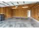 Inside a spacious, unfinished two car garage with access door and concrete floors at 1211 Brown Velvet Ln, Apex, NC 27523