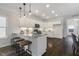 Bright kitchen features white cabinets, granite countertops, stainless steel appliances, and a stylish island with seating at 1211 Brown Velvet Ln, Apex, NC 27523