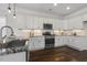 Bright kitchen features white cabinets, granite countertops, stainless steel appliances, and wood floors at 1211 Brown Velvet Ln, Apex, NC 27523