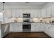 Kitchen featuring white cabinets, granite countertops, stainless steel appliances, and wood floors at 1211 Brown Velvet Ln, Apex, NC 27523