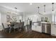 View from kitchen into dining area featuring a fireplace, wood floors, and stainless steel appliances at 1211 Brown Velvet Ln, Apex, NC 27523