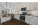 Kitchen featuring white cabinets, granite countertops, stainless steel appliances, and wood floors at 1211 Brown Velvet Ln, Apex, NC 27523