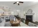 Open living room featuring a fireplace, ceiling fan, and dark hardwood flooring at 1211 Brown Velvet Ln, Apex, NC 27523
