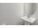 Bright powder room featuring a pedestal sink, oval mirror, and ample wall space at 1211 Brown Velvet Ln, Apex, NC 27523