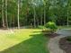 This backyard features a well maintained lawn and shady trees at 128 Madison Ct, Siler City, NC 27344