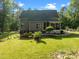 The beautiful backyard features a screened-in porch, a landscaped yard and mature trees at 128 Madison Ct, Siler City, NC 27344