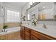 Bright bathroom featuring a double sink vanity, soaking tub, and a large window at 128 Madison Ct, Siler City, NC 27344