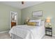 Carpeted bedroom with ceiling fan, side tables, lamps, and bathroom view at 128 Madison Ct, Siler City, NC 27344