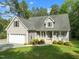 Inviting home exterior showcasing a well-manicured lawn, attached garage, and covered front porch with a seating area at 128 Madison Ct, Siler City, NC 27344