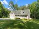 Charming home with a two-car garage, front porch, manicured lawn, and mature trees on a sunny day at 128 Madison Ct, Siler City, NC 27344