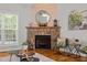 Stone fireplace featuring wood accent, decorative mirror, hearth, and window to the exterior at 128 Madison Ct, Siler City, NC 27344