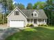Lovely home with a well-maintained lawn, attached garage, and inviting front porch with green landscaping at 128 Madison Ct, Siler City, NC 27344