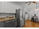 Eat-in kitchen features stainless appliances, white and gray cabinetry and wood flooring at 128 Madison Ct, Siler City, NC 27344