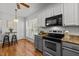 Eat-in kitchen with stainless appliances, white and gray cabinetry and wood flooring at 128 Madison Ct, Siler City, NC 27344