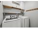 Bright laundry room with wood shelves, hooks and Samsung washer and dryer at 128 Madison Ct, Siler City, NC 27344