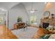 Open living room with cathedral ceiling, stone fireplace, hardwood floors, and a large window at 128 Madison Ct, Siler City, NC 27344
