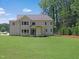 Manicured backyard showing the home's rear facade, showcasing a well-maintained lawn and outdoor space at 1444 Old Apex Rd, Cary, NC 27513