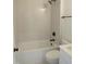 A well-lit bathroom featuring a shower/tub with white subway tiles, toilet, and matte black fixtures at 1444 Old Apex Rd, Cary, NC 27513